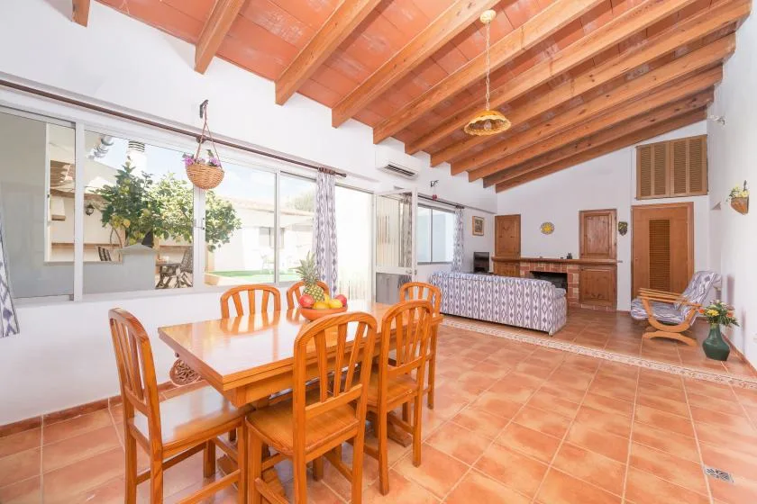 A dining area with a wooden table and seating beneath exposed ceiling beams.