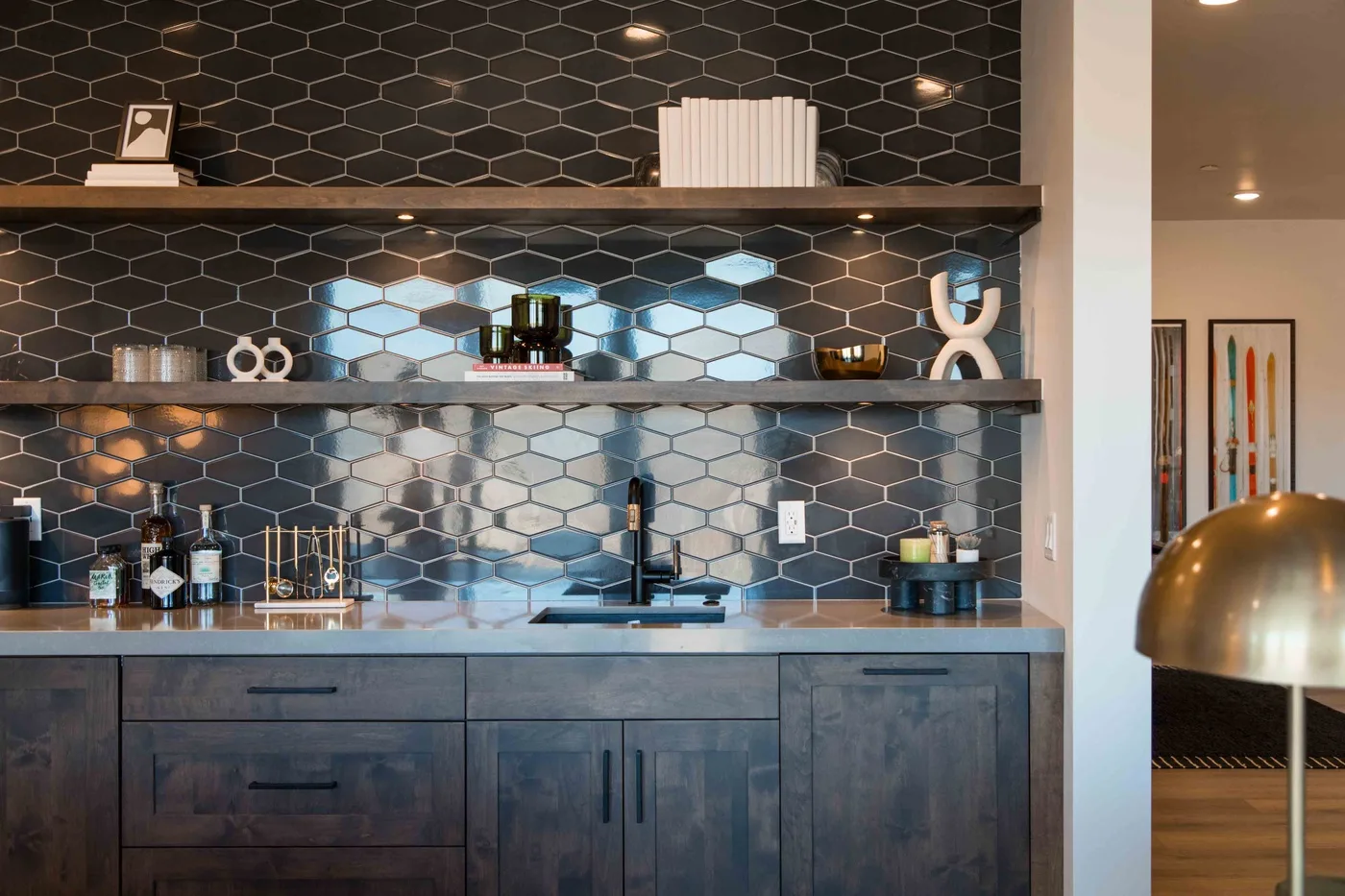 A modern kitchen with dark cabinetry, a sink, and a tiled backsplash.