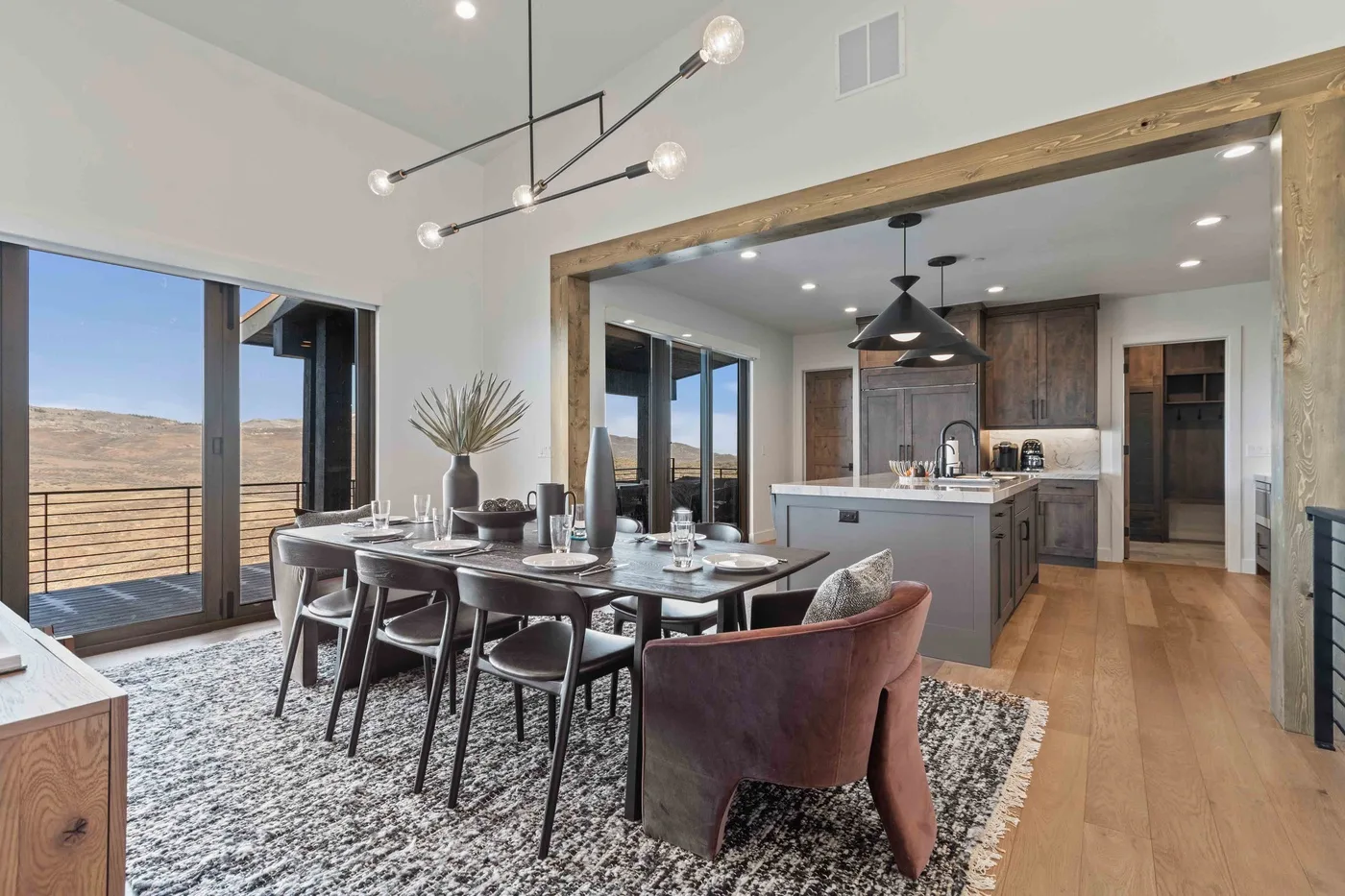 An open-plan dining area and kitchen with a long table and island.