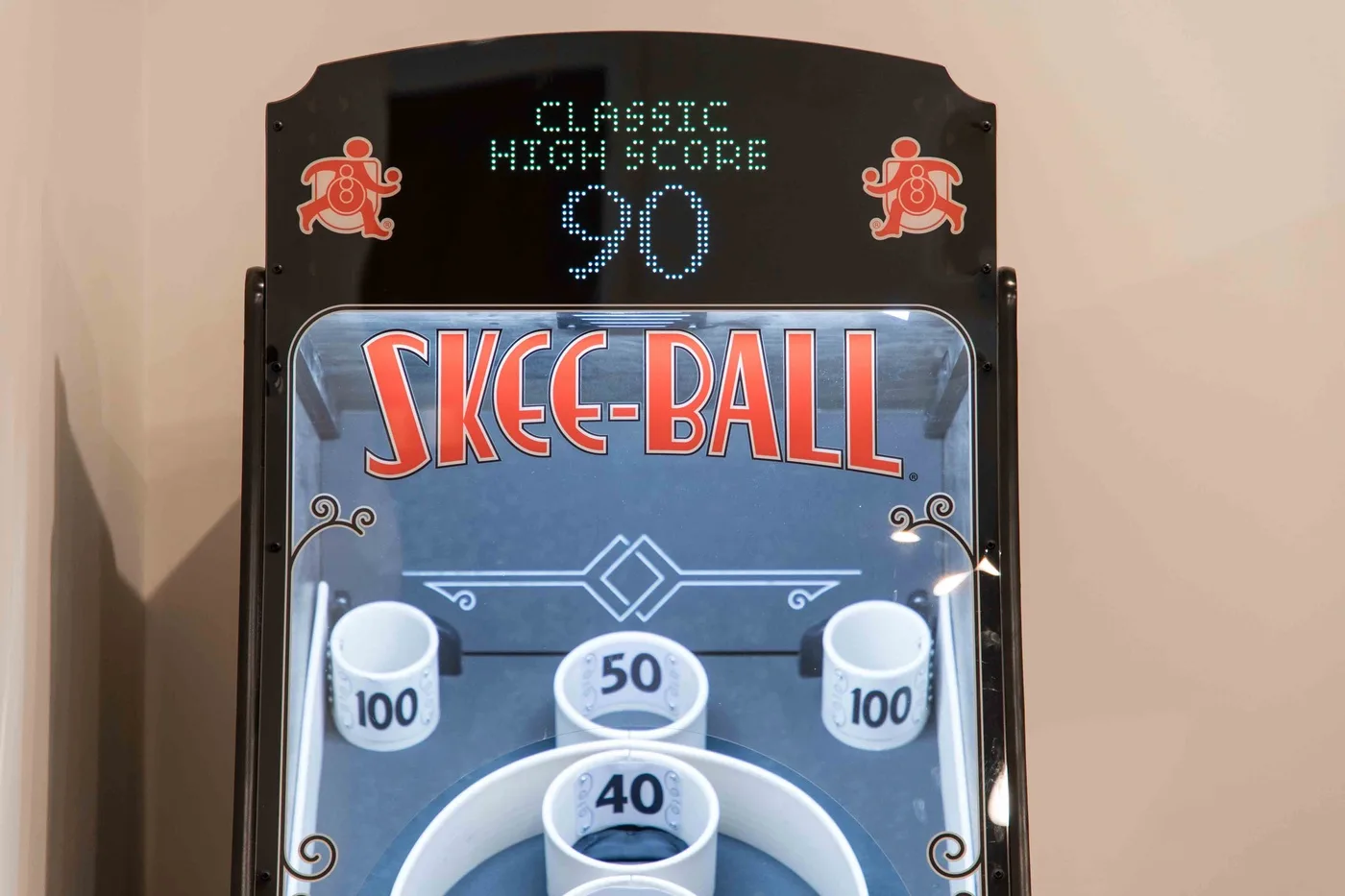 A skee-ball arcade game with a digital scoreboard and numbered scoring holes.