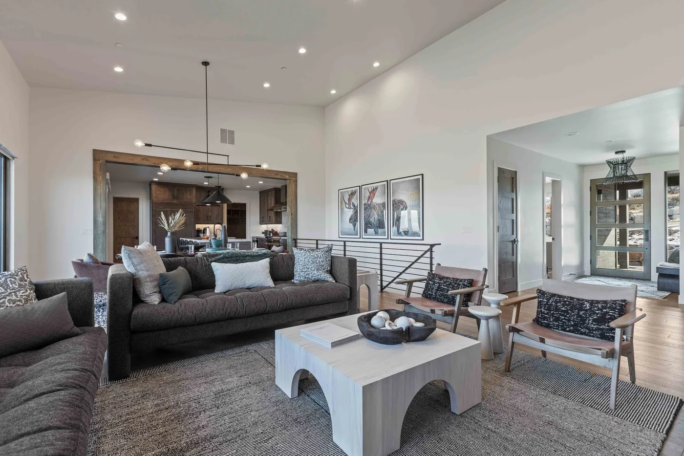 A spacious living room with seating, a coffee table, and an open kitchen beyond.