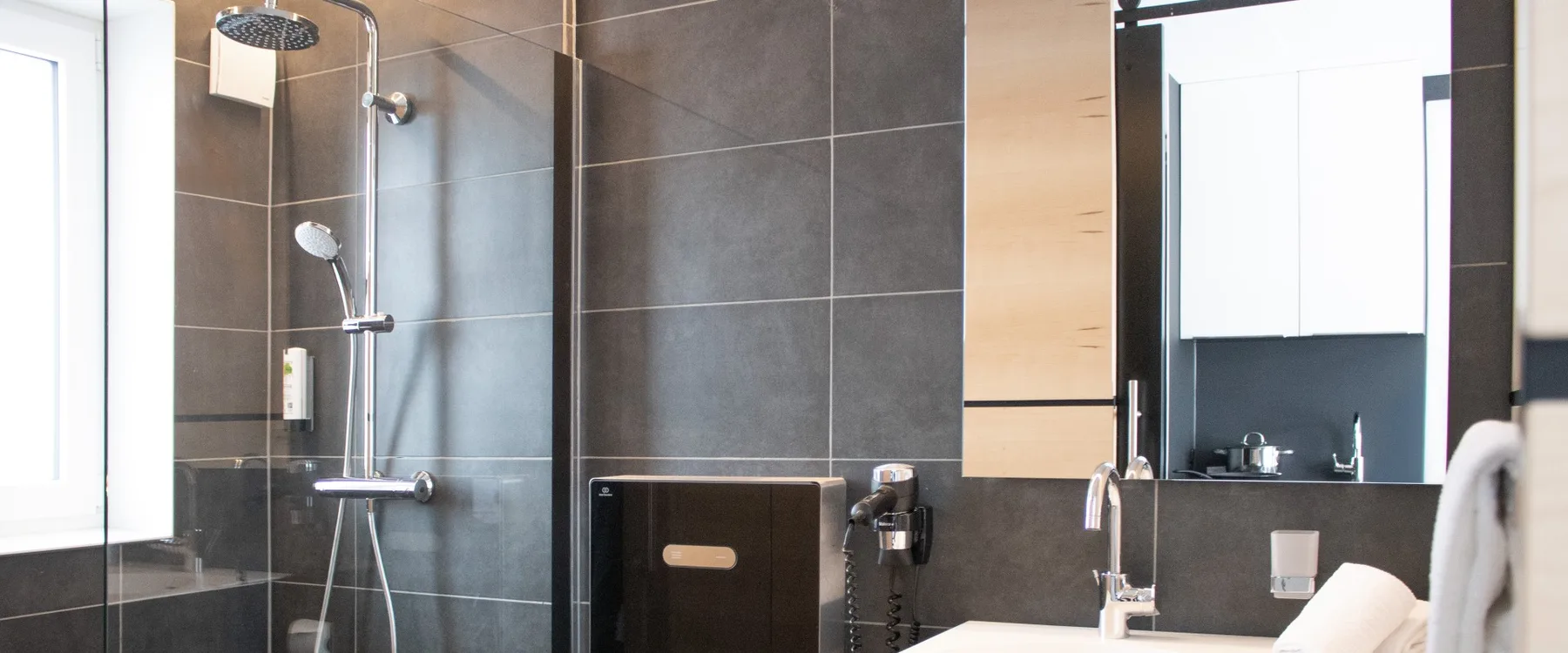 Bathroom with walk-in rain shower, sink and hair dryer