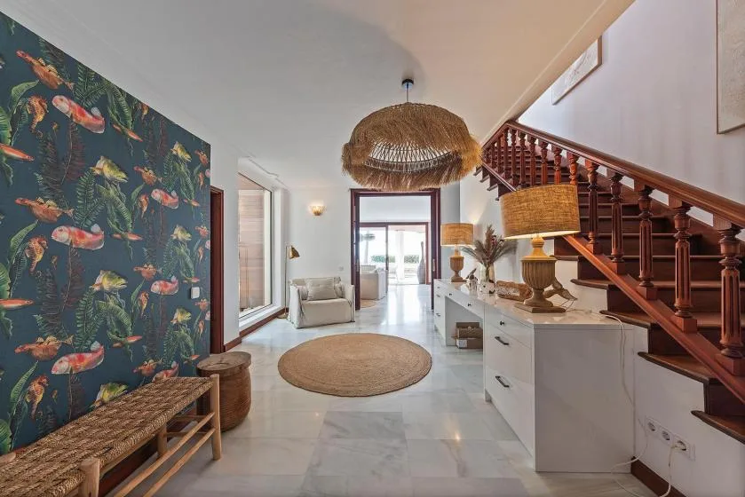 A bright entry hall with a staircase and a round woven rug.