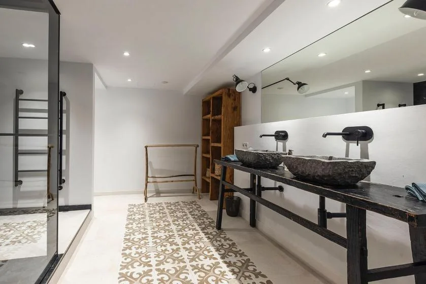 A bright bathroom with two vessel sinks along a long counter.