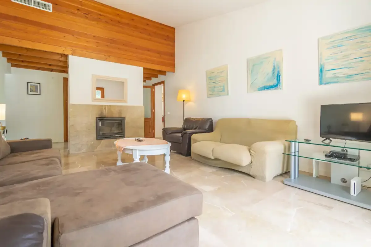 Una sala de estar con asientos, una mesa de centro y un televisor.