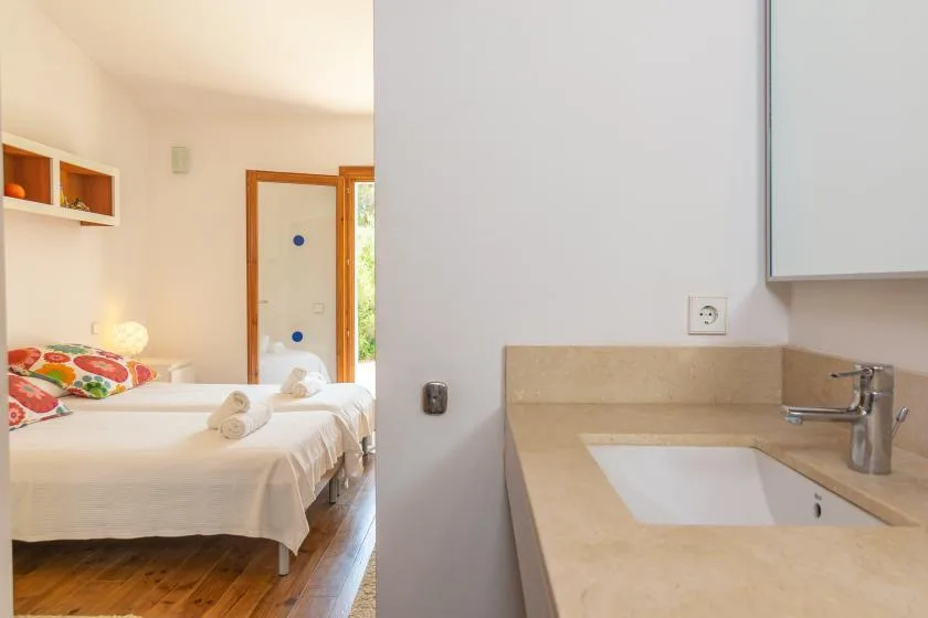Un dormitorio con dos camas junto a un lavabo de baño.