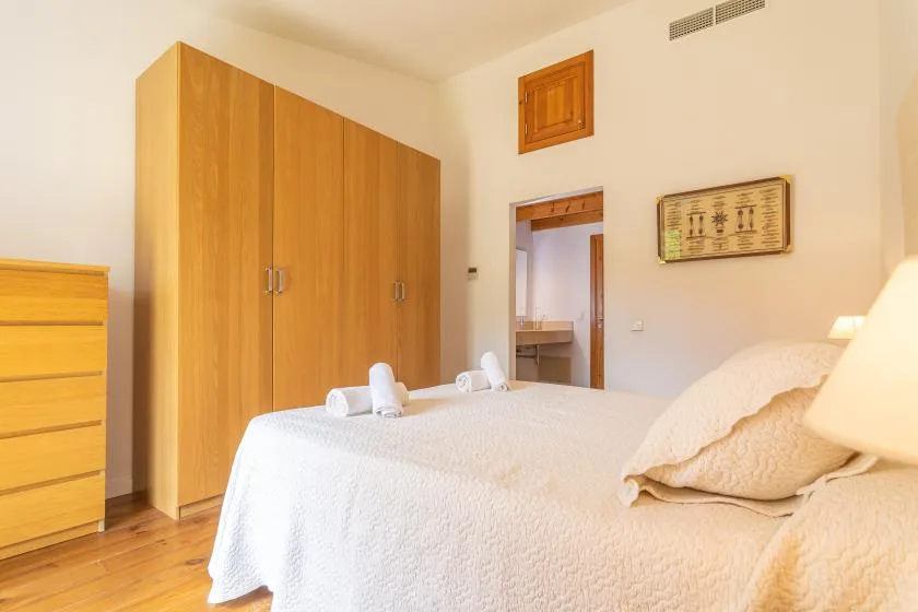 Un dormitorio con una cama grande y armarios de madera.