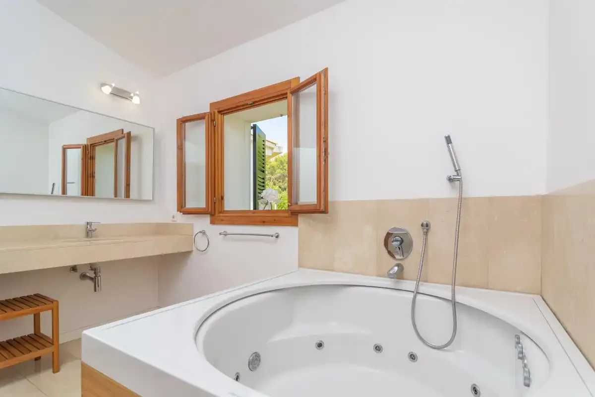 Un baño con una bañera grande empotrada y una ducha de pared.