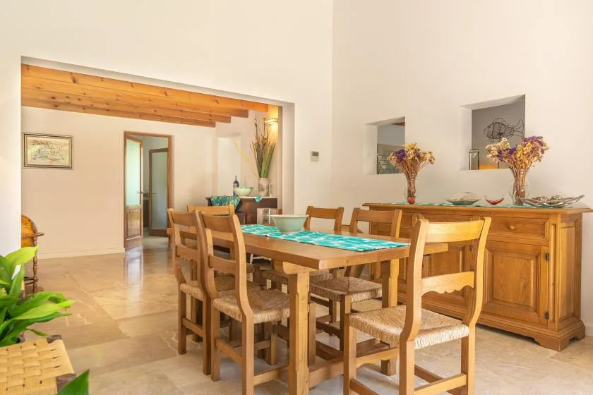 Un comedor con una mesa larga de madera y sillas a juego.