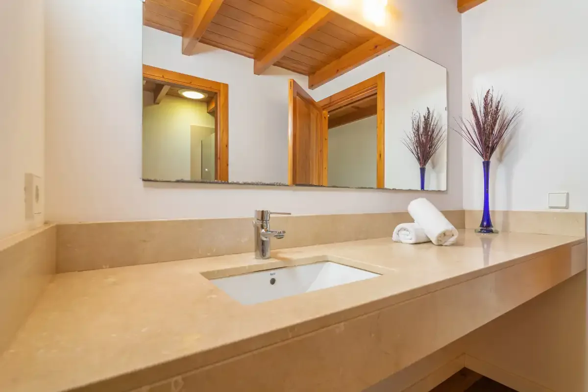 Un lavabo de baño con una amplia encimera, un fregadero y un gran espejo.