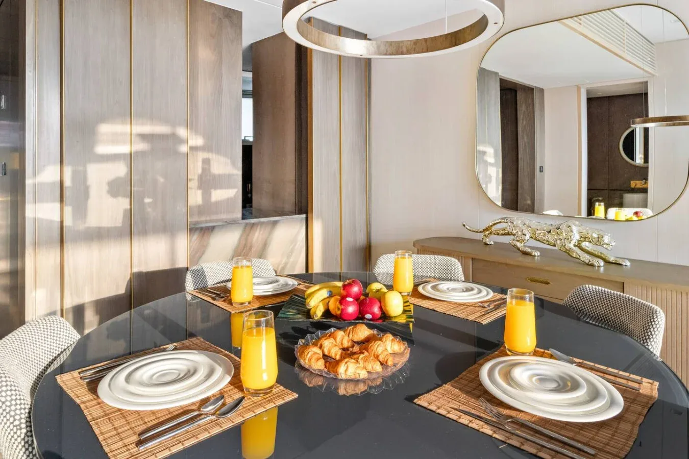 Un comedor con la mesa puesta y un espejo grande sobre la encimera.
