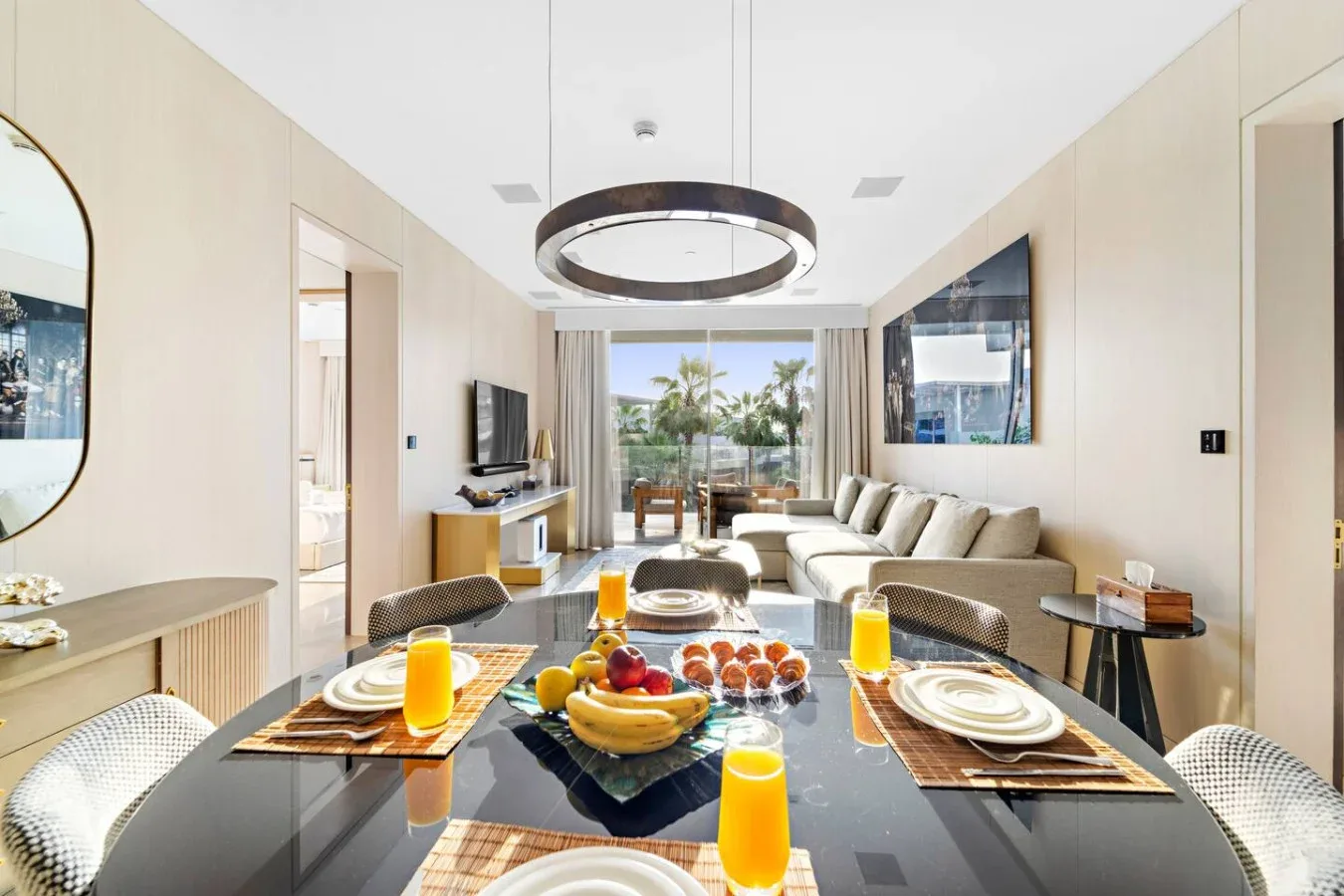 Un luminoso salón-comedor con la mesa puesta y asientos junto a las ventanas.