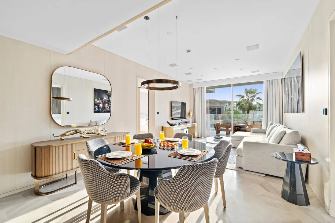 Un luminoso comedor y sala de estar con mesa, asientos y ventanas con vista a un balcón.