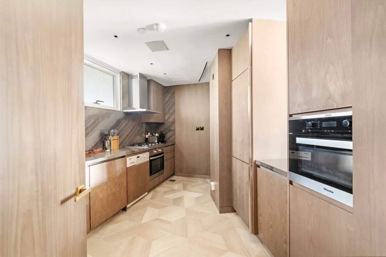 Una cocina moderna con gabinetes de madera, una encimera y electrodomésticos integrados.