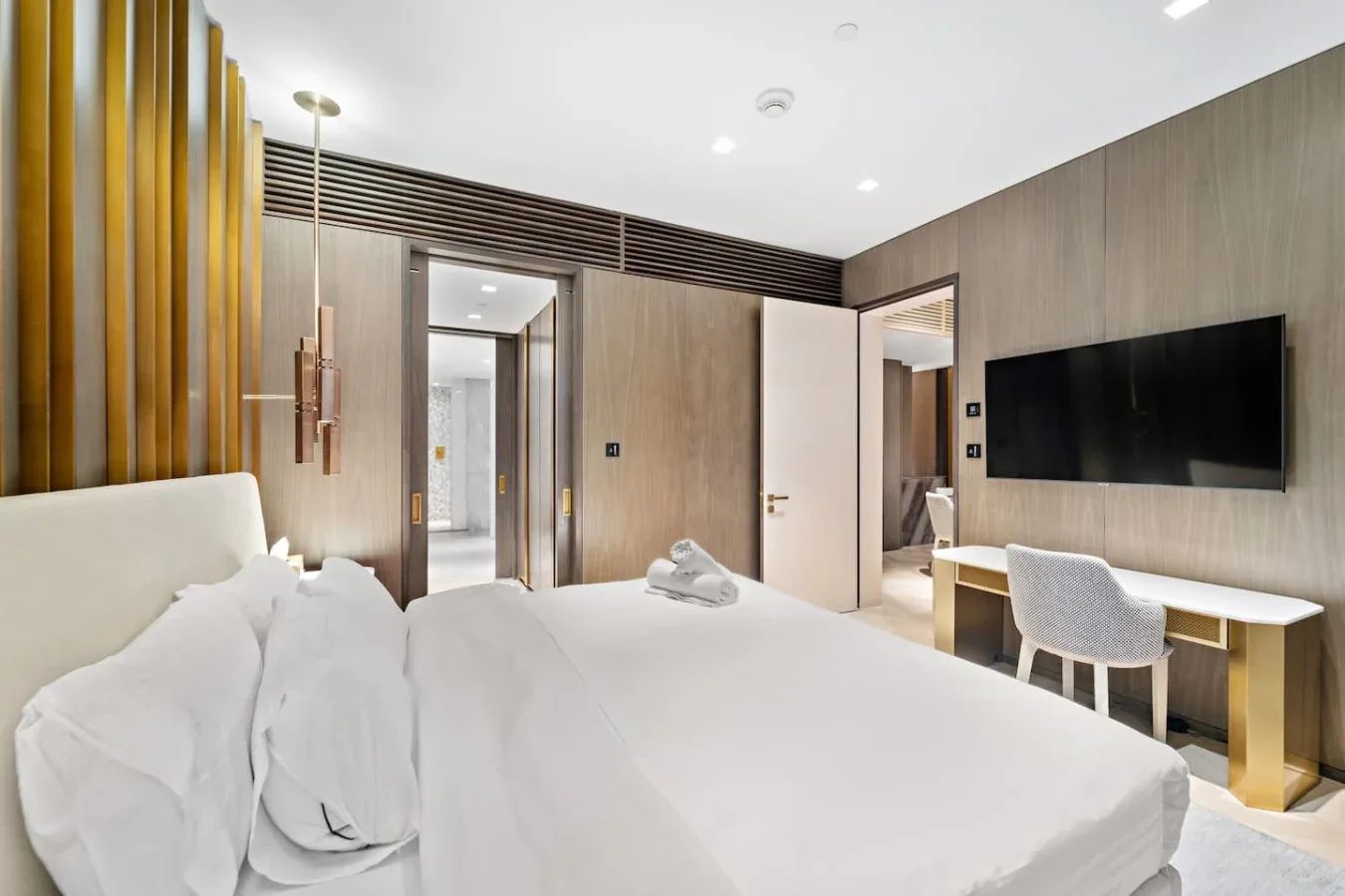 Un dormitorio con una cama grande y un televisor montado en la pared.
