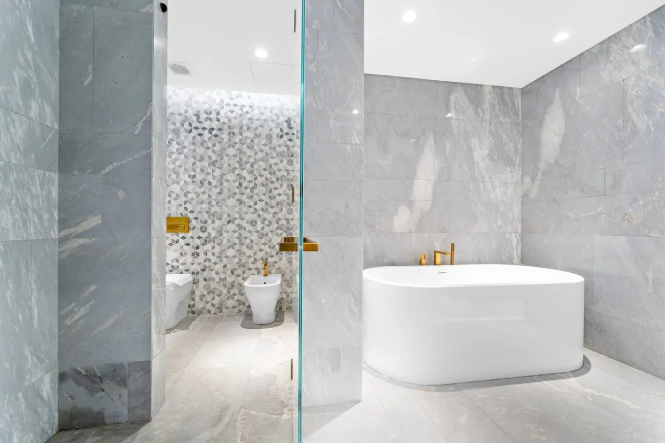 Un baño moderno con bañera exenta y una zona de ducha con mampara de vidrio.