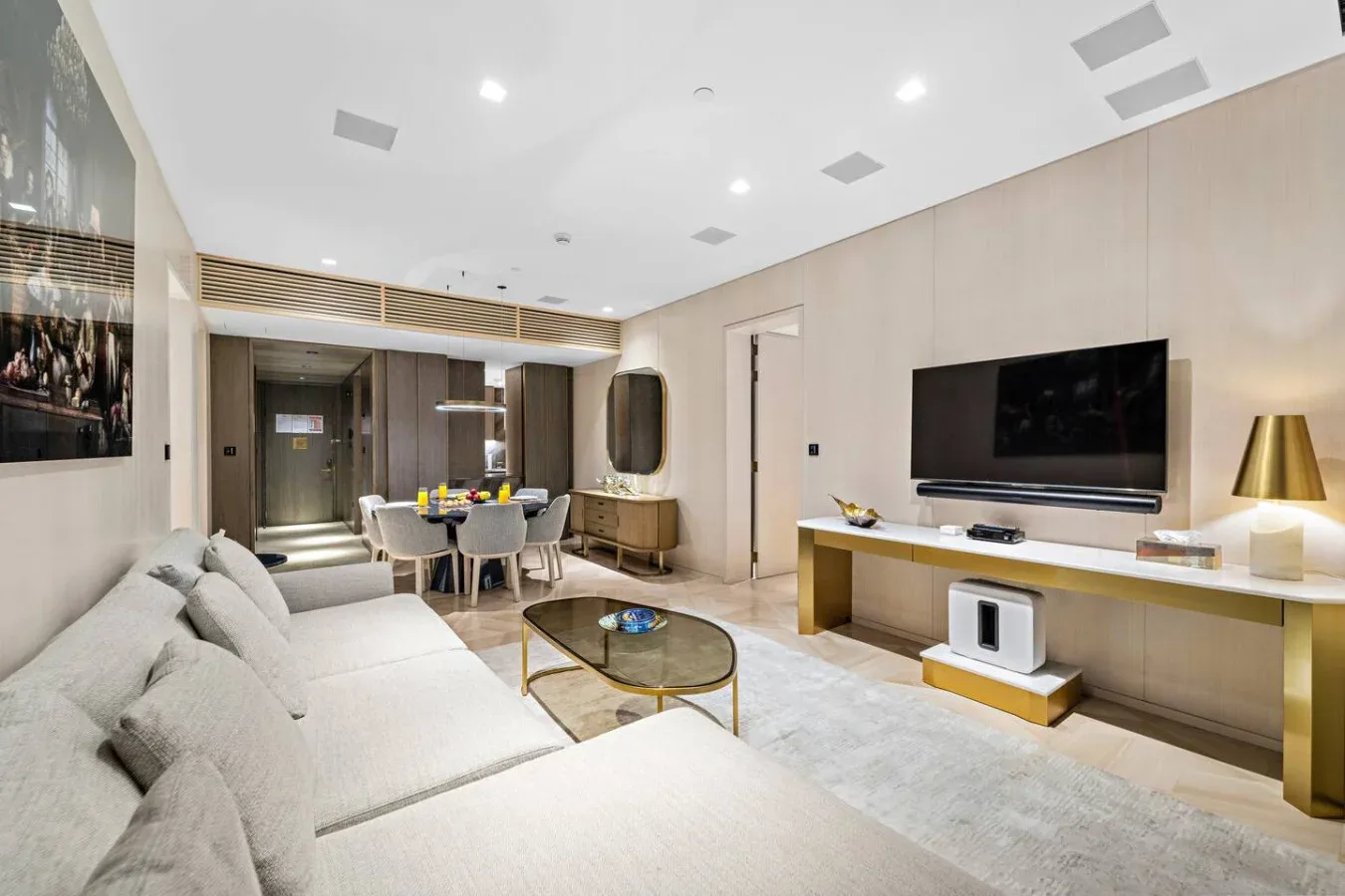 Una sala luminosa con asientos, un televisor y un comedor.