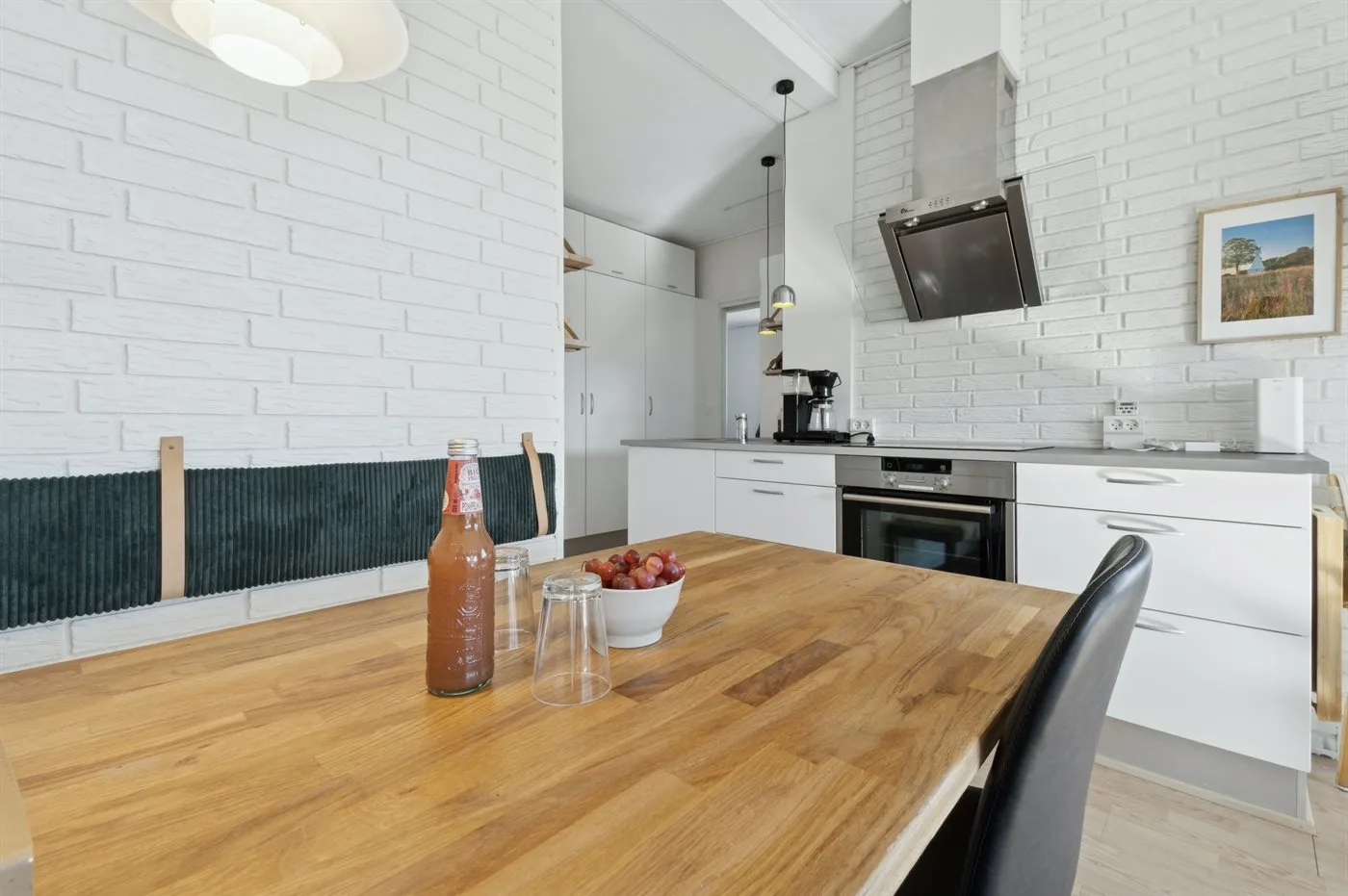 Una cocina con gabinetes blancos y una mesa de comedor de madera.