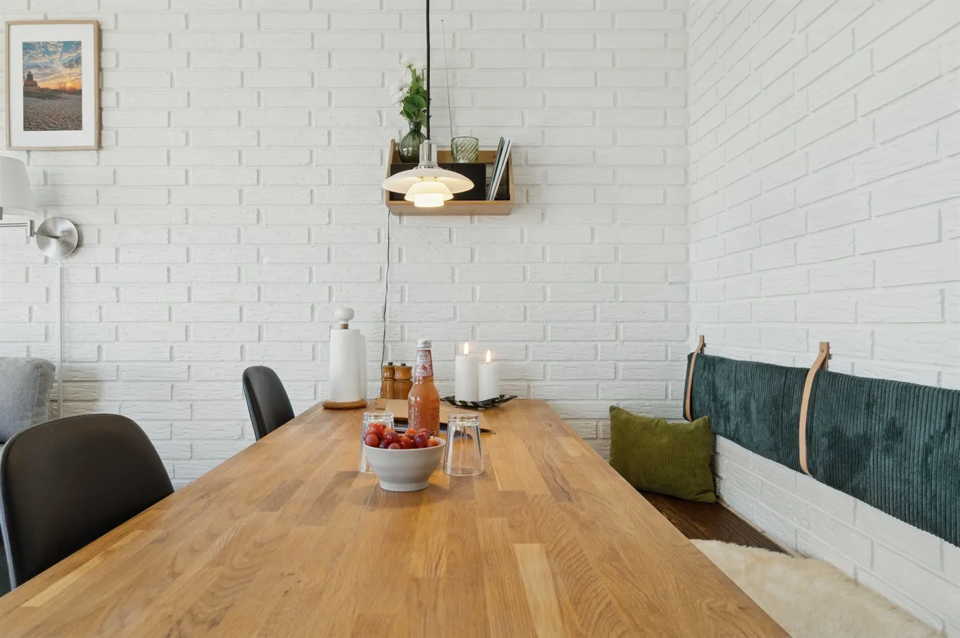 Comedor con una mesa larga de madera y asientos junto a la pared.
