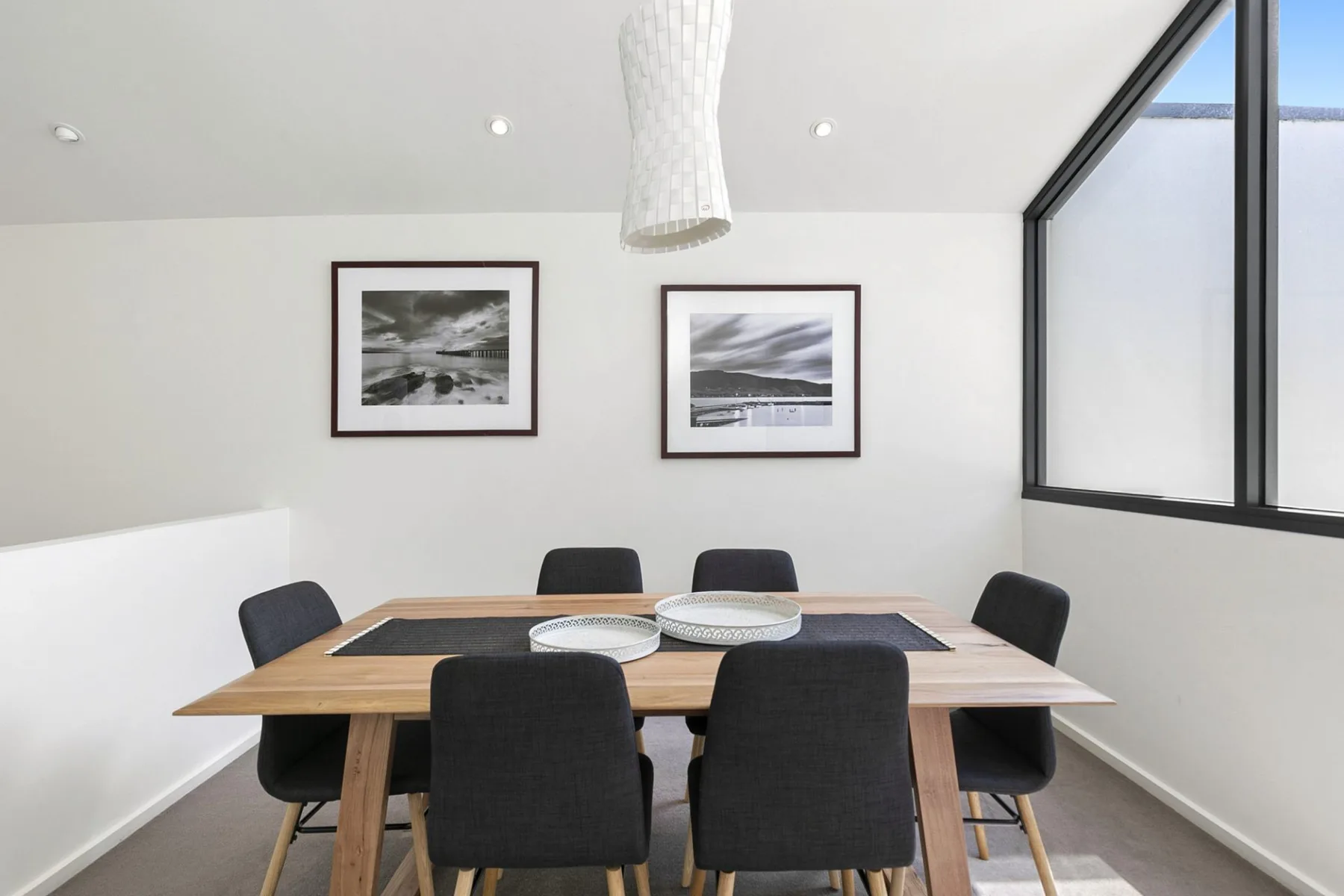 A dining area with a wooden table and dark upholstered seating.
