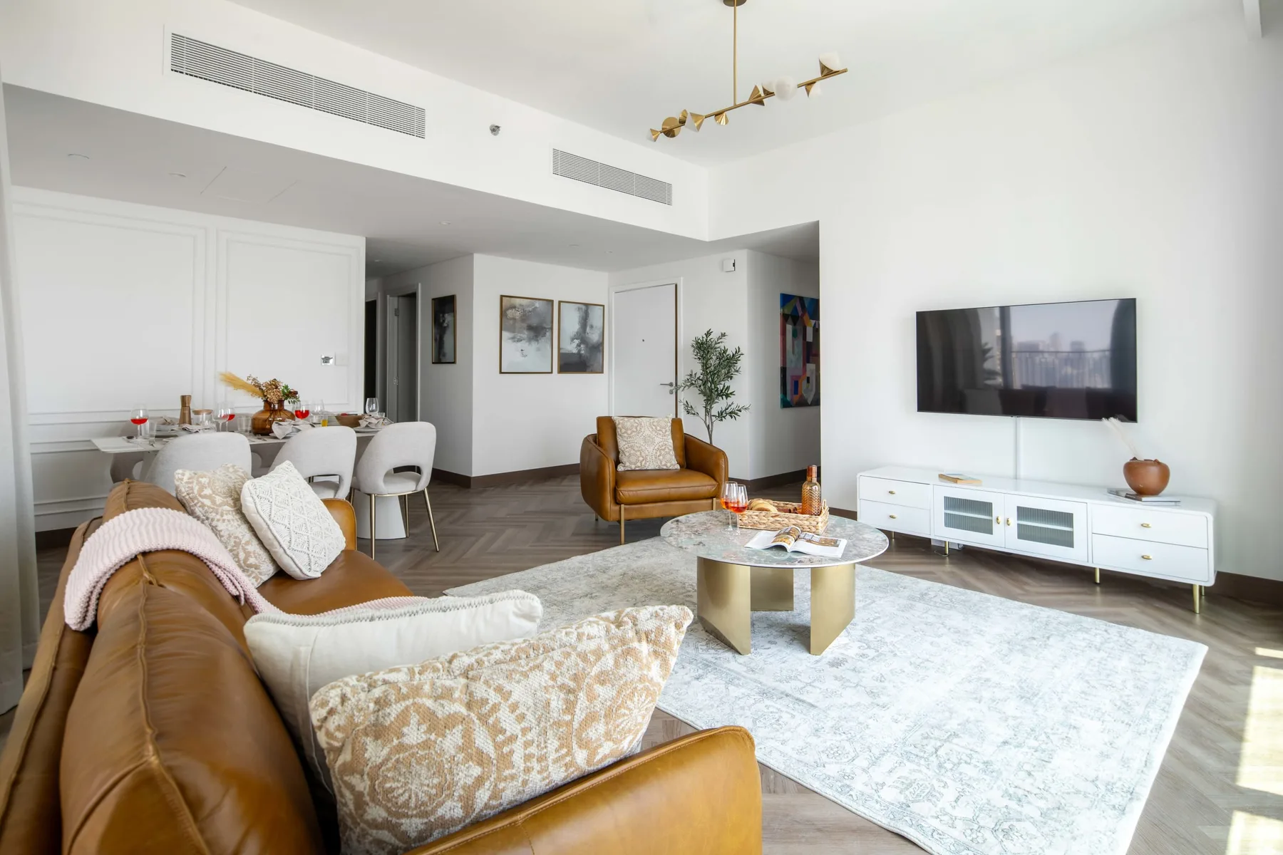 Una sala de estar luminosa con asientos, una mesa de centro y un televisor.
