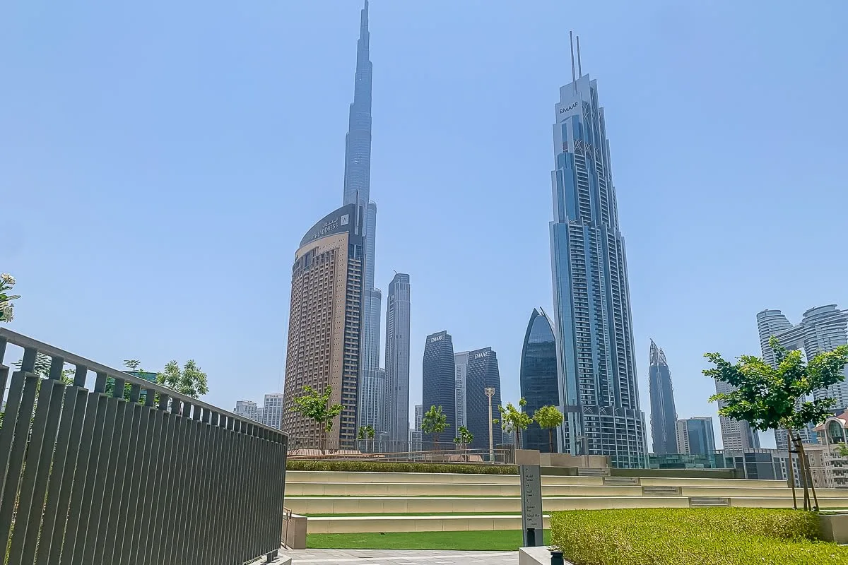 Un horizonte urbano con altos rascacielos modernos se alza detrás de un parque con césped.