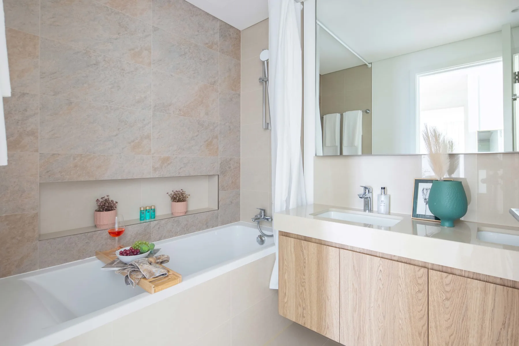 Un baño luminoso con bañera, tocador con espejo y una ventana.