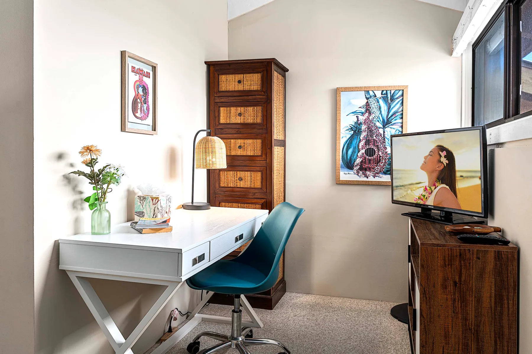 Un espacio de trabajo luminoso cuenta con un escritorio blanco, una silla verde azulada y una cómoda de madera.