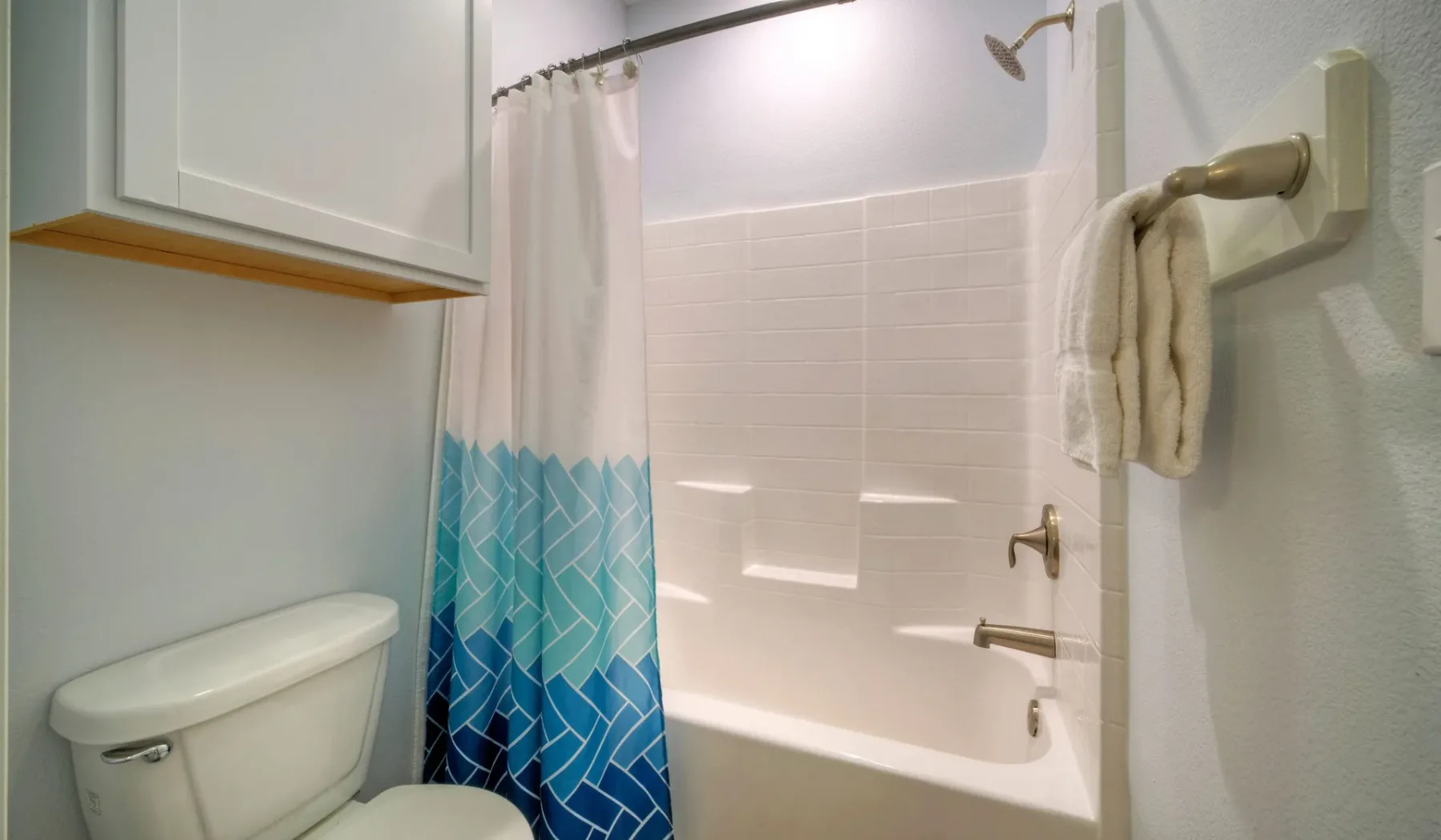 Un baño con bañera, cortina de ducha e inodoro.