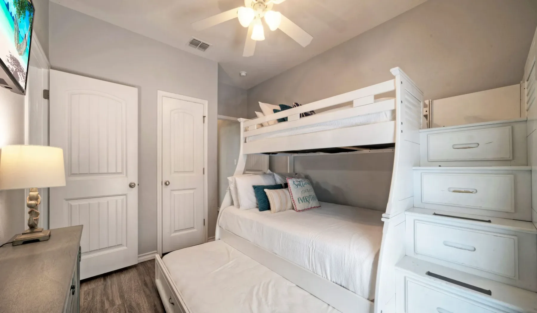 Un dormitorio con una litera blanca y cajones integrados.