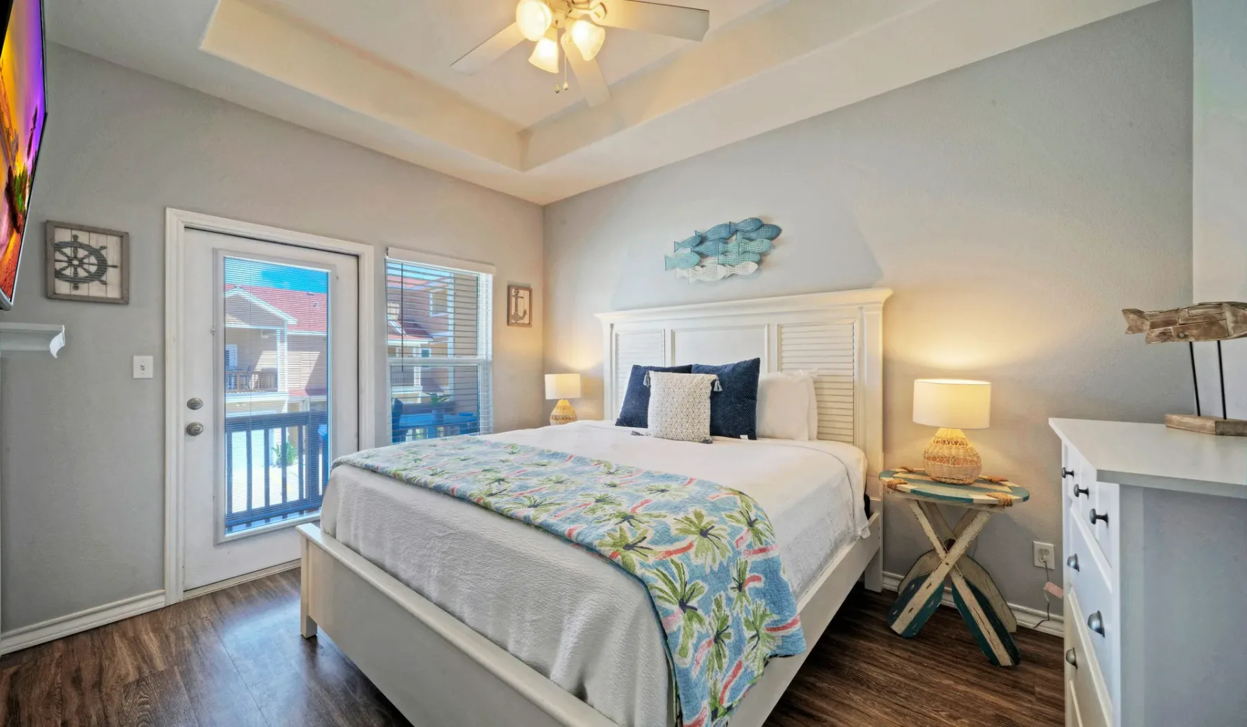 Un dormitorio luminoso con una cama grande y puertas de vidrio que dan a un balcón.