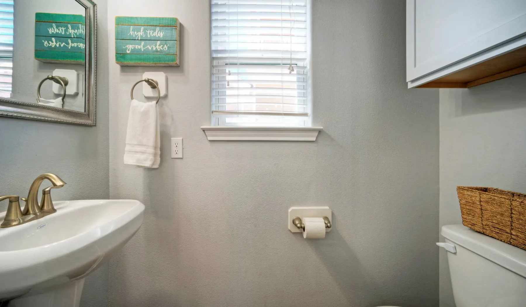 Un baño con lavabo, inodoro y una ventana con persianas.