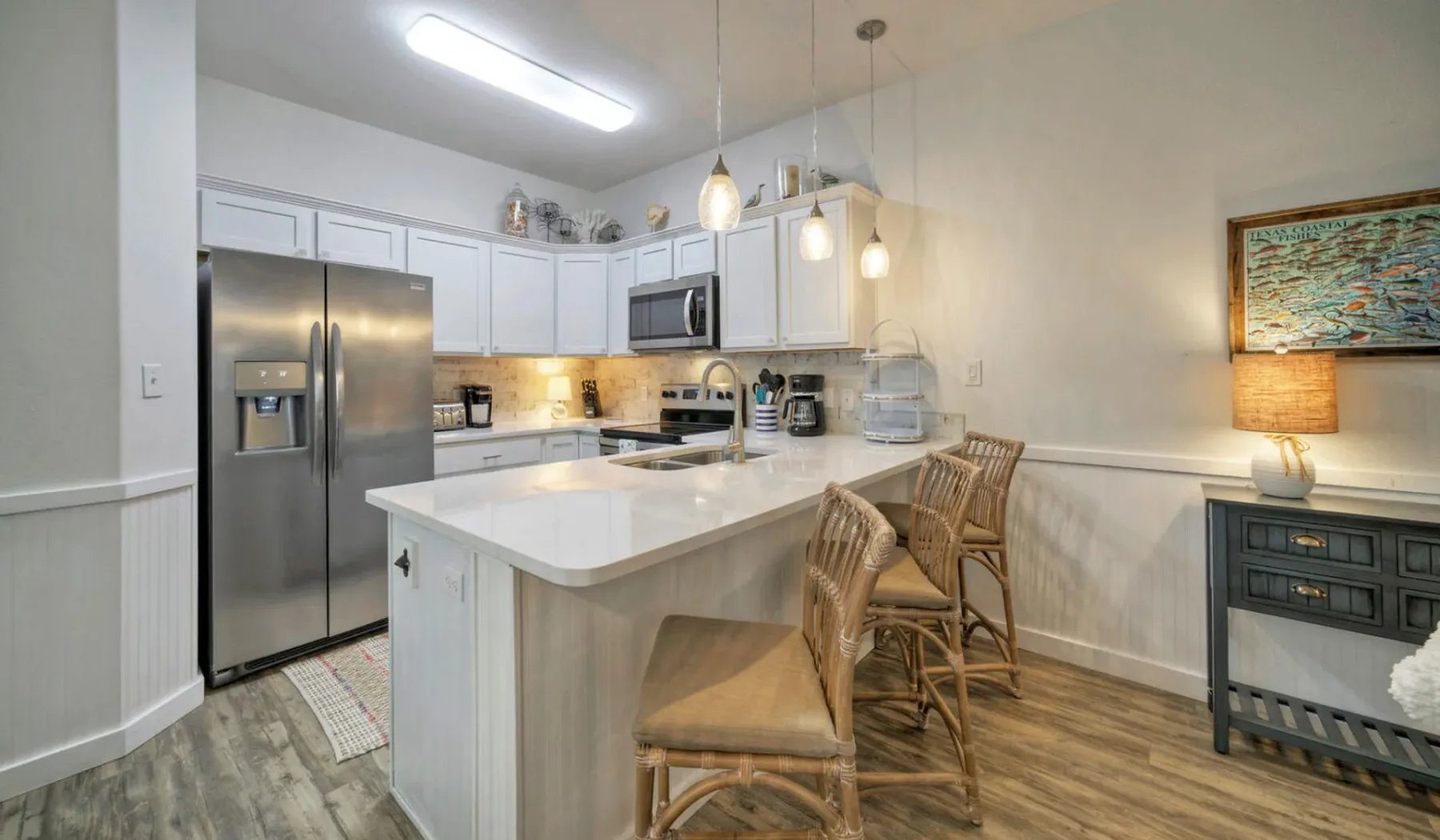 Una cocina luminosa con una isla central y asientos de barra.