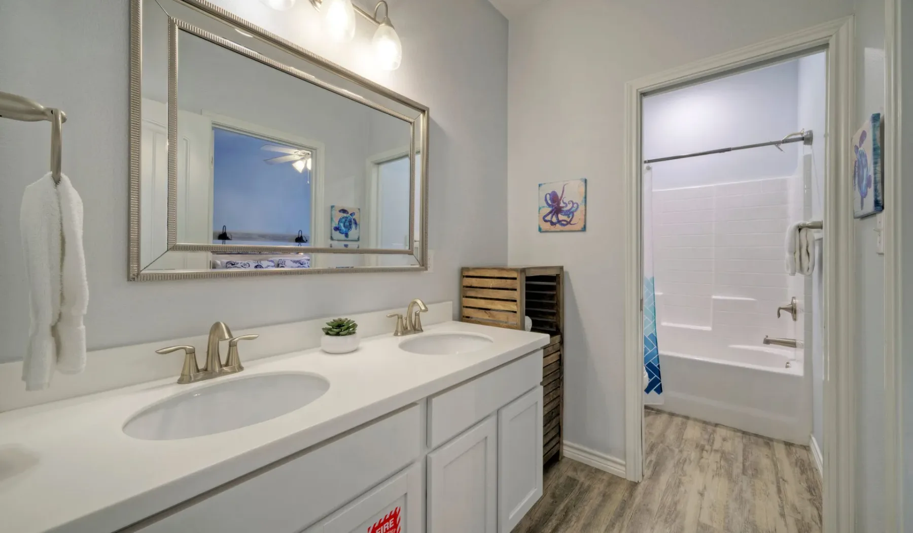 Un lavabo de baño con un espejo grande está junto a una zona de ducha abierta.