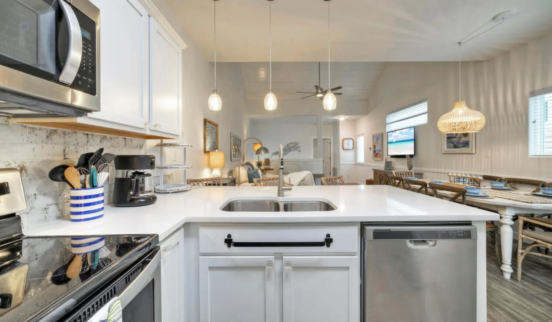 Una cocina luminosa con una isla central, electrodomésticos de acero inoxidable y un comedor.