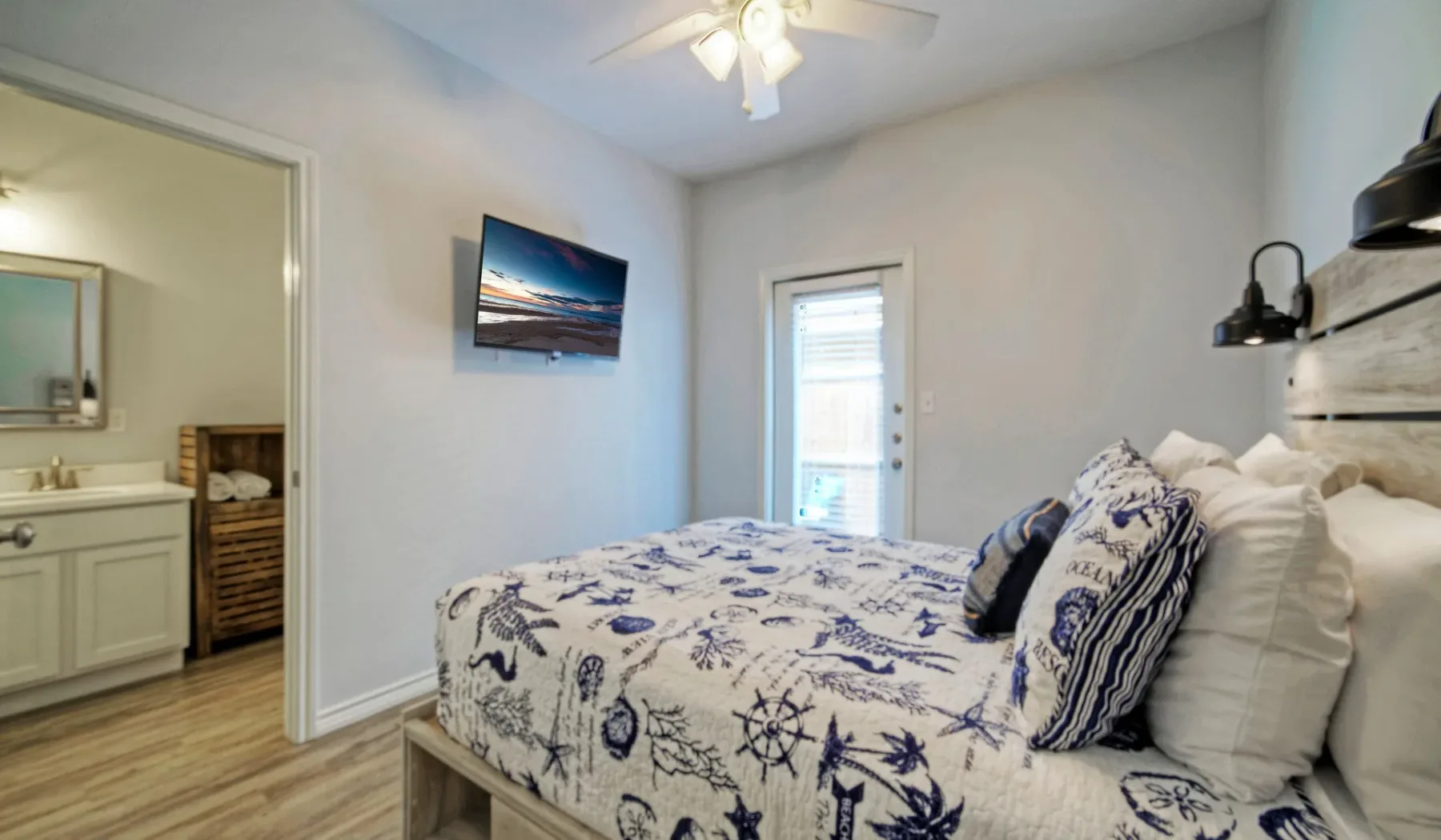 Un dormitorio con una cama cubierta con ropa de cama estampada en azul y blanco.