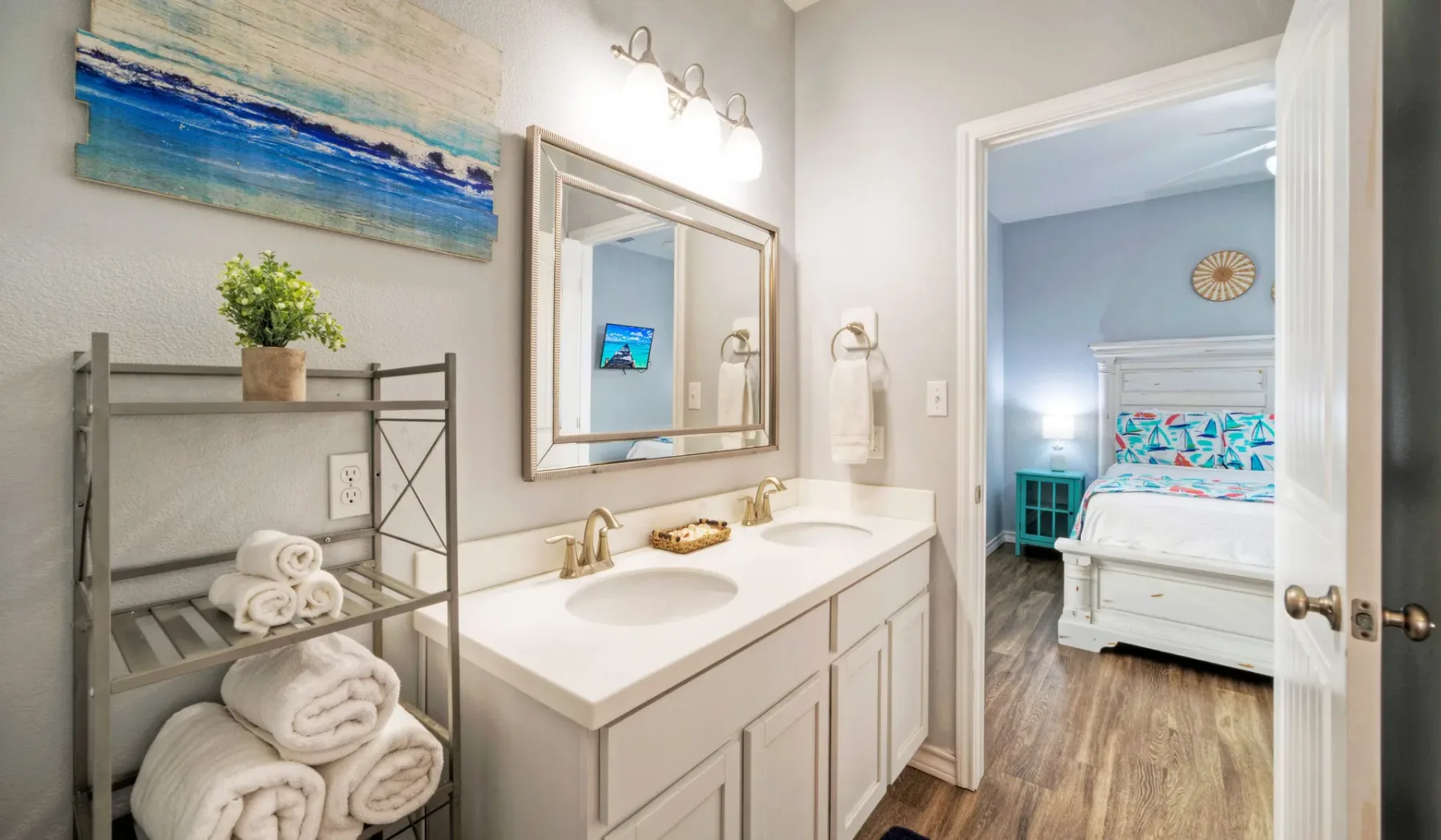 Un lavabo de baño da paso a un dormitorio con una cama.
