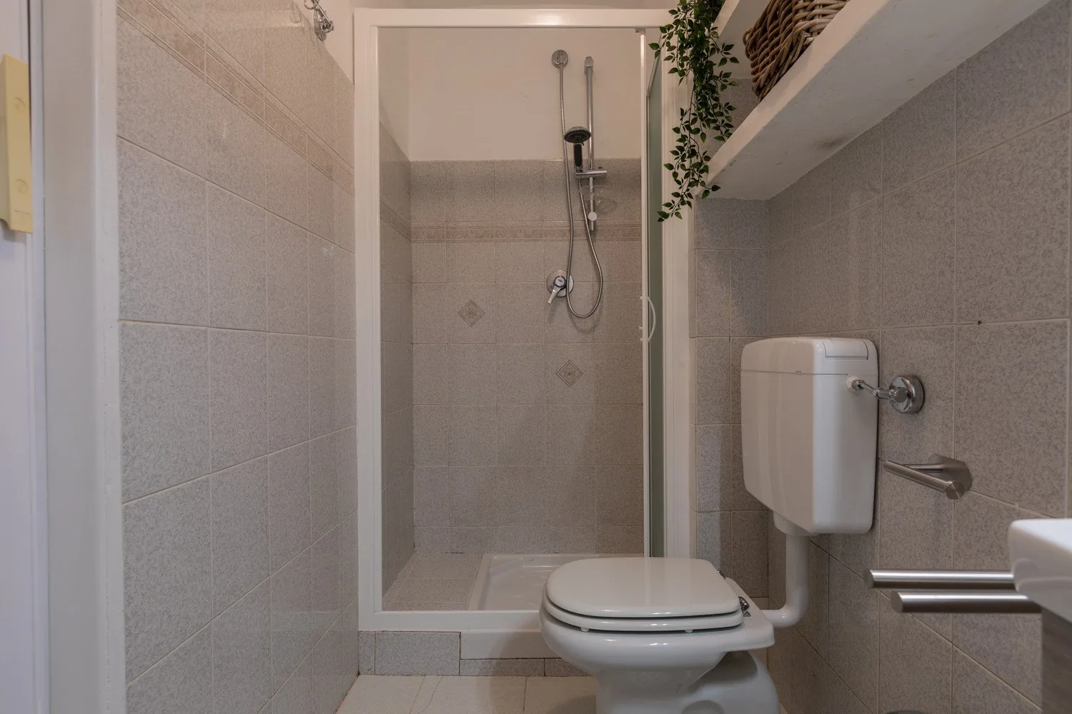 Un baño con azulejos, ducha e inodoro.