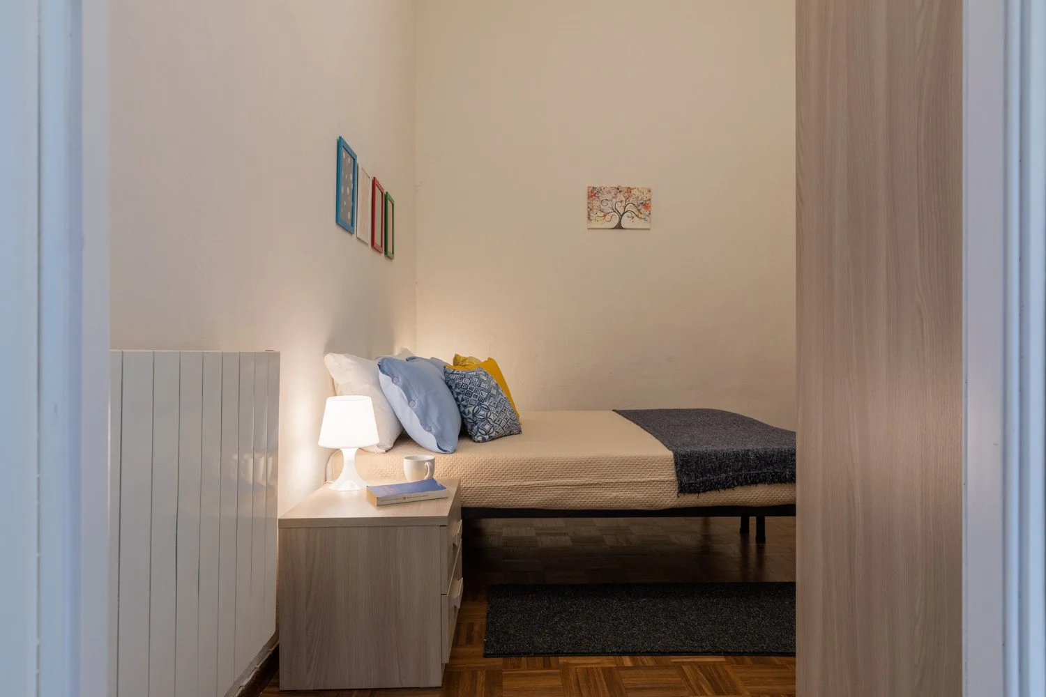 Un dormitorio con una cama tendida y una mesita de noche.
