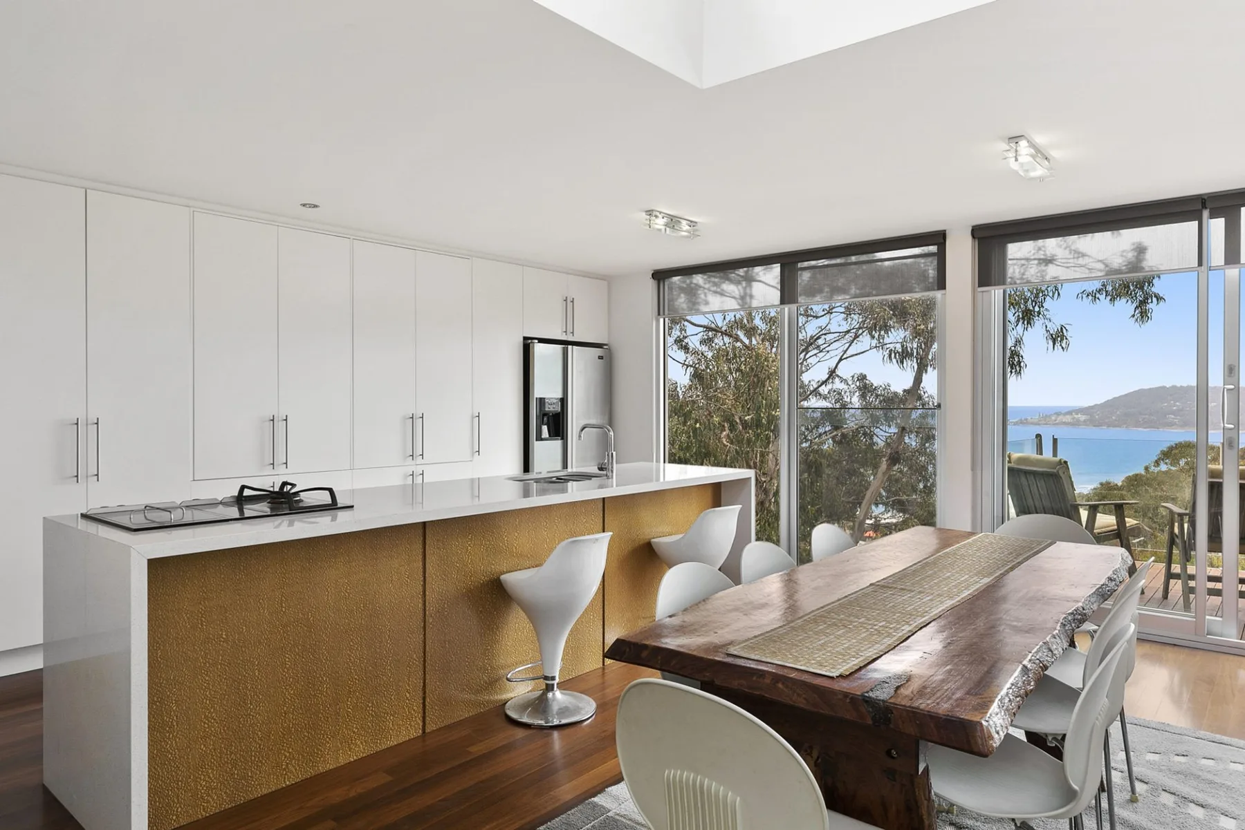 A bright kitchen and dining area with large windows overlooking the water.
