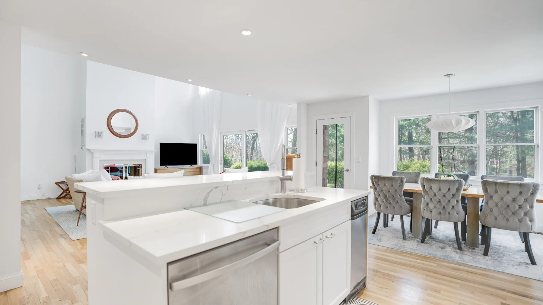 Cocina y comedor diáfanos y luminosos, con una isla grande y ventanas.