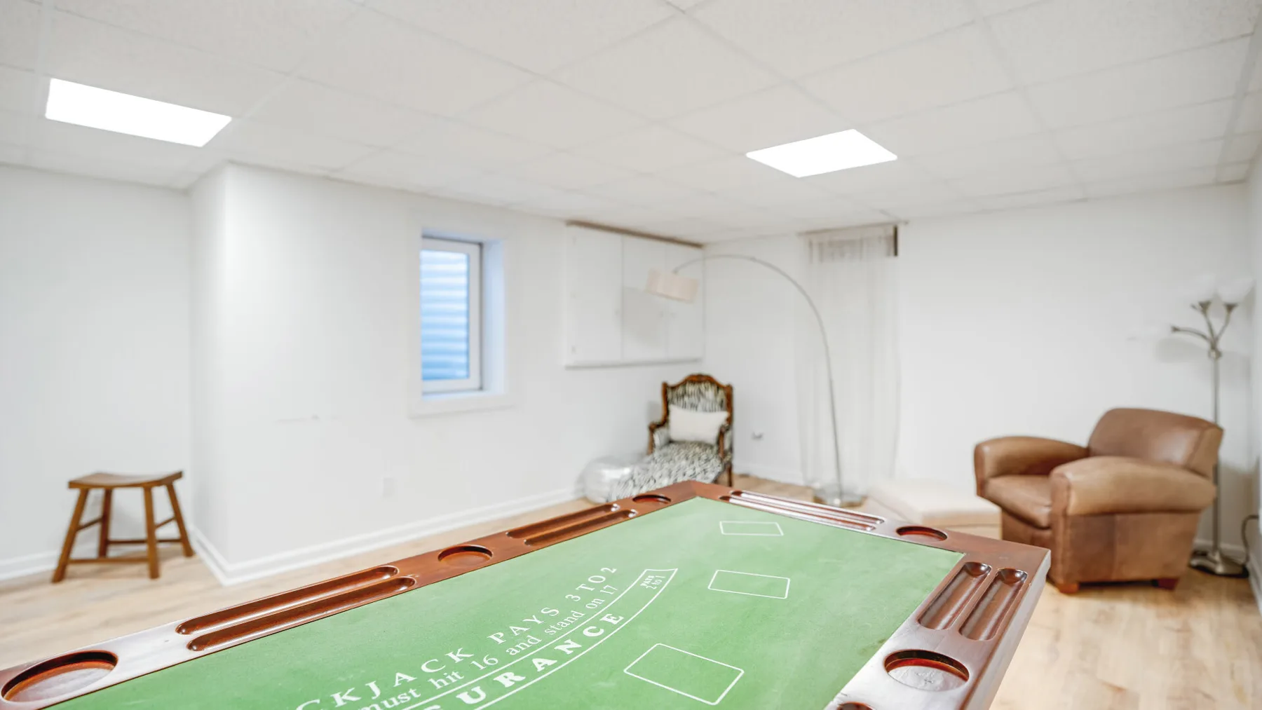 Una sala de juegos luminosa con una mesa de shuffleboard verde y asientos.