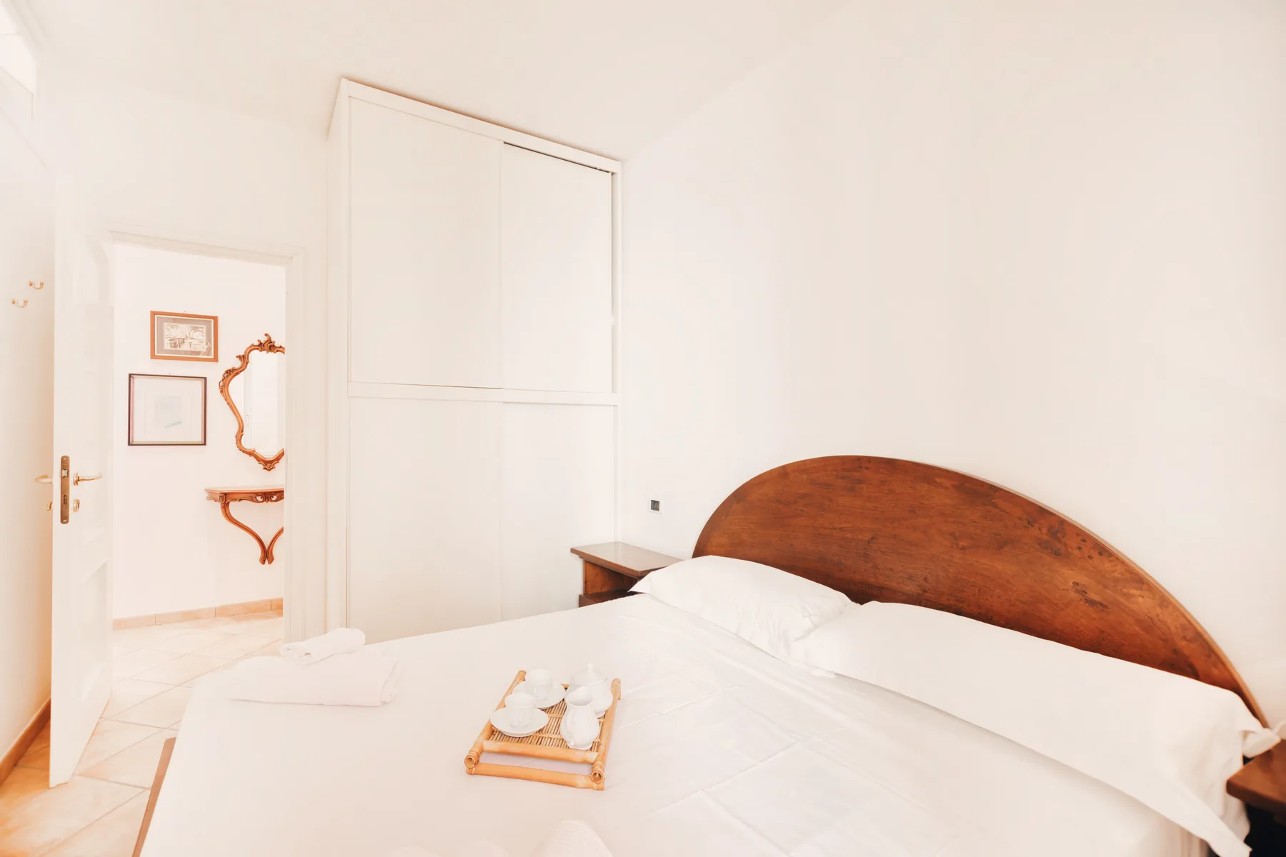 A bedroom with a bed and a curved wooden headboard.