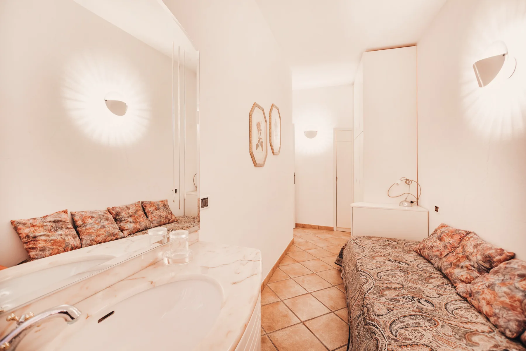 A bright bathroom with a bathtub and patterned seating.