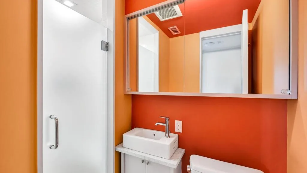 Un baño luminoso con un lavabo blanco y un armario con espejo.