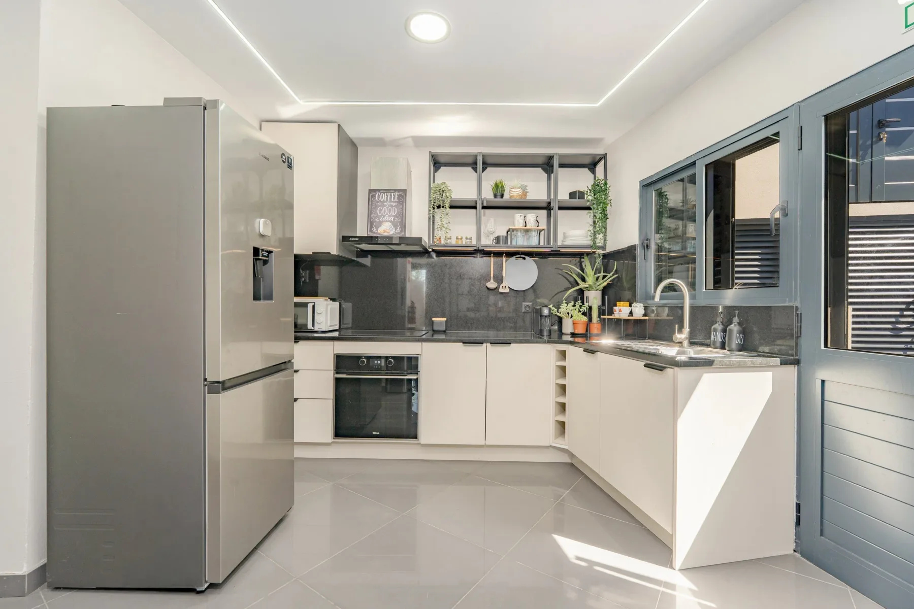 Kitchen with stainless steel appliances, white cabinetry, and open shelving.