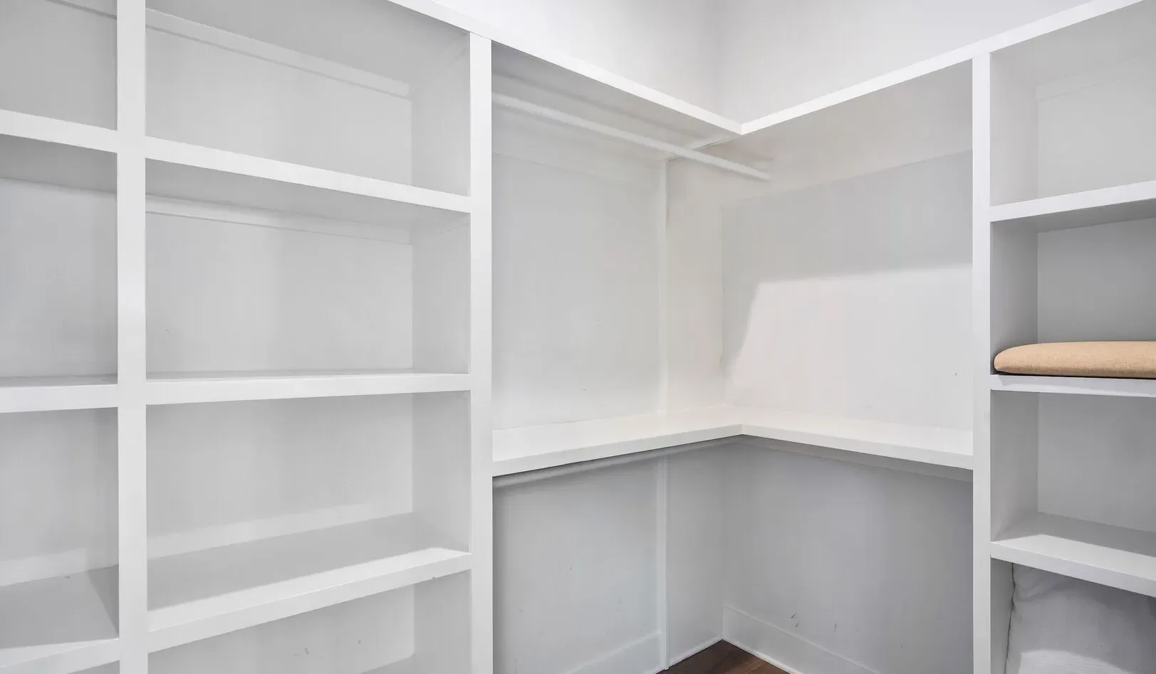 A bright walk-in closet with built-in shelving along the walls.