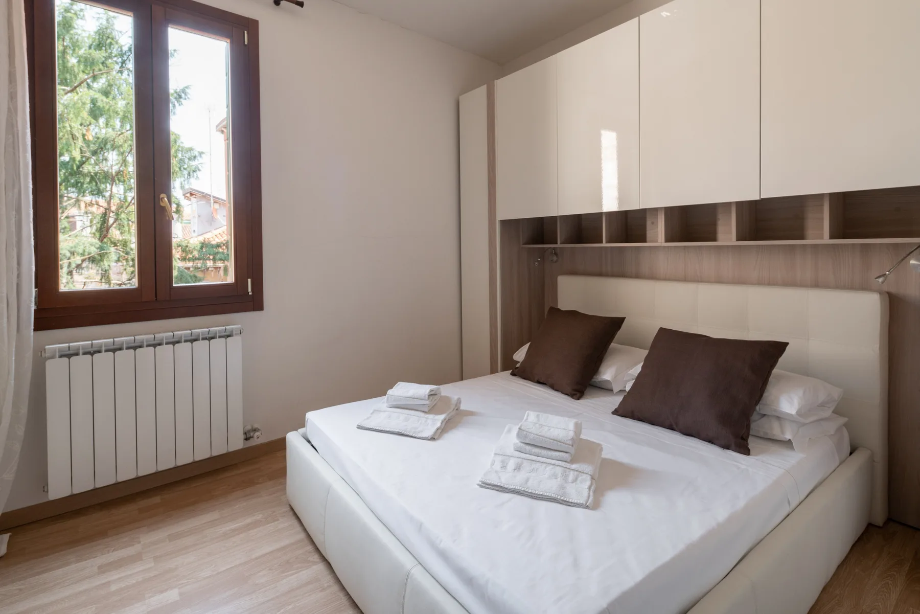 Un dormitorio con una cama bien tendida y armarios empotrados.
