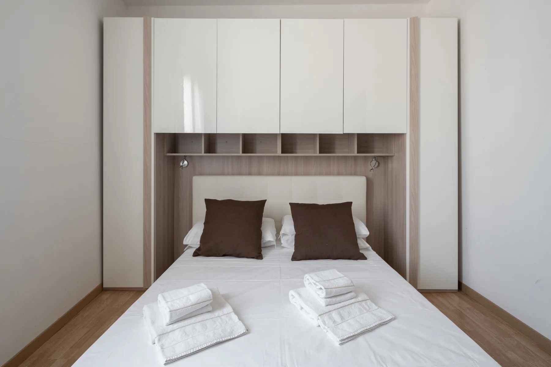 Un dormitorio con una cama bien tendida y toallas dobladas.
