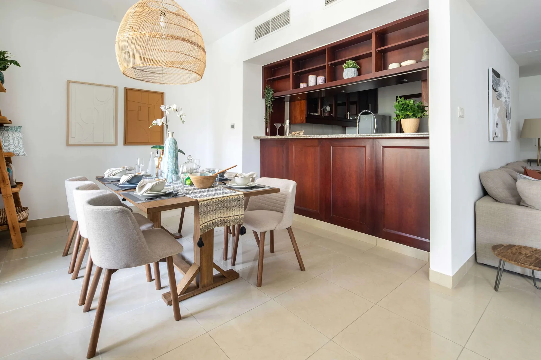 A dining area with a set table beside a dark wood kitchen counter.